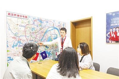 10月10日，武汉德佑鑫朝飞-世茂天胤店，置业顾问为魏先生、李女士推荐新的二手房源。 （湖北日报全媒记者 任勇 摄）